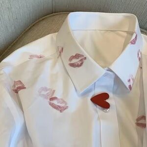 White button-up shirt with red lipstick kisses and heart-shaped buttons